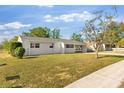 White, single-story home with a covered carport and well-maintained lawn at 80 Garrison Ln, Frostproof, FL 33843