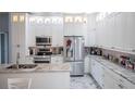 Modern kitchen with white cabinets, granite counters, and stainless steel appliances at 8243 Alturas Rd, Bartow, FL 33830