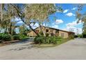 Side view of a brick home with large windows, surrounded by trees and shrubs at 9 Skidmore Rd, Winter Haven, FL 33884