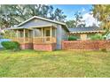 Gray house with wooden porch, brick accents, and a large yard at 2036 Lake Ariana Blvd, Auburndale, FL 33823