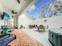 Spacious covered patio with brick flooring, hot tub, and seating area at 235 Lake Suzanne Dr, Lake Wales, FL 33859