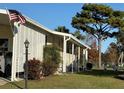 Side view of mobile home showcasing landscaping and a lamp post at 418 Village Sw Cir, Winter Haven, FL 33880