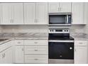 Modern kitchen with stainless steel appliances and white cabinets at 609 Estrada Ln, Kissimmee, FL 34758
