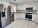 Modern kitchen with stainless steel appliances and white cabinets at 609 Estrada Ln, Kissimmee, FL 34758