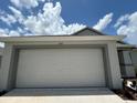 White two-car garage with a clean and modern look at 1049 Bergamot Dr, Bartow, FL 33830