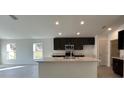 Modern kitchen featuring dark cabinets, an island, and stainless steel appliances at 2169 Emma Ln, Lake Wales, FL 33859