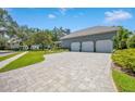 Three-car garage with paver driveway and mature landscaping at 122 Stone Hill Dr, Maitland, FL 32751