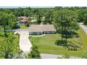 Single-story house with a large backyard, surrounded by lush greenery and trees at 213 Riverbend Rd, Ormond Beach, FL 32174