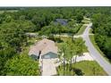 An aerial view of a house nestled in a wooded neighborhood, showcasing its curb appeal at 213 Riverbend Rd, Ormond Beach, FL 32174