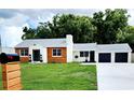 Updated ranch home with white and wood siding, two-car garage, and a well-maintained lawn at 210 W Illiana St, Orlando, FL 32806