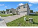 Two-story home with attached garage and landscaped yard at 2557 Shamrock St, Tavares, FL 32778