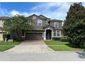 Two-story house with a brown facade and brick driveway at 1402 Wexford Way, Davenport, FL 33896