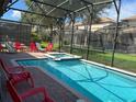 Screened pool and spa with red lounge chairs at 1402 Wexford Way, Davenport, FL 33896