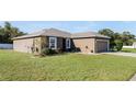 Side view of the house showcasing a large grassy yard at 7878 Tanbier Dr, Orlando, FL 32818