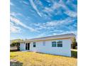 Rear view of the house showcasing a sliding glass door and grassy yard at 9115 Se 88Th St, Ocala, FL 34472