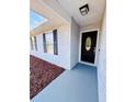 Front entrance with black door and gray concrete walkway at 9115 Se 88Th St, Ocala, FL 34472
