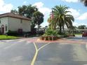 Another gated entrance to the community, showing palm trees and a flag at 6274 Whispering Way # 130, Orlando, FL 32807