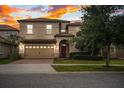 Two-story house with a two-car garage and manicured lawn at 1502 Moon Valley Dr, Davenport, FL 33896