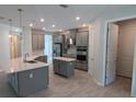 Modern kitchen with gray cabinets, island, and stainless steel appliances at 3937 Reed Grass Pl, Kissimmee, FL 34746