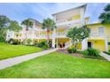 Three-story yellow building with balconies and tropical landscaping at 716 Lucaya Loop # B1/U716, Davenport, FL 33897