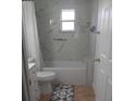 Clean bathroom with bathtub, toilet, and marble-style wall at 1323 Kory St, Kissimmee, FL 34741