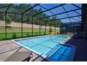 Screened in rectangular pool with spa and lounge chairs at 1470 Moon Valley Dr, Davenport, FL 33896