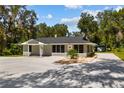 Newly renovated house with gray exterior and large windows at 8941 E County Road 466, The Villages, FL 32162