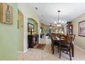 Elegant dining room with a chandelier and access to the living room at 384 Grand Canal Dr, Poinciana, FL 34759