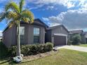 Gray house with dark brown garage door and landscaping at 8581 Rindge Rd, Polk City, FL 33868