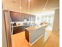 Spacious kitchen with dark cabinets, granite countertops, and tile floors at 2585 Needlepoint St, Kissimmee, FL 34741