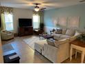 Living room with sectional sofa, large TV, and a cozy armchair at 301 Las Fuentes Dr, Kissimmee, FL 34746