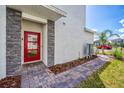 Townhouse entrance with red door and stone accents at 891 Ocean Course Ave # 0, Davenport, FL 33896