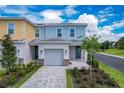 Two-story townhome with attached garage and paved driveway at 7901 Putting Green Way, Reunion, FL 34747