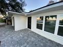 Modern front entrance with black door and gray paver walkway at 1204 Lake Elbert Se Dr, Winter Haven, FL 33880