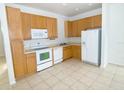Small kitchen with light wood cabinets, white appliances, and tile floor at 2374 Caravelle Cir, Kissimmee, FL 34746