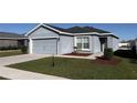 Gray house with a two-car garage and landscaping at 305 Cascara Ln, Auburndale, FL 33823