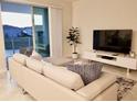 Spacious living room with a large TV, comfortable seating, and balcony access at 3131 Paradox Circle # 207, Kissimmee, FL 34746