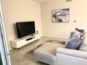 Light-filled living room featuring a sectional sofa and modern media console at 3131 Paradox Circle # 207, Kissimmee, FL 34746