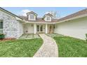 Elegant entryway with stonework, double doors, and a landscaped walkway at 7920 Summer Ridge Pl, Orlando, FL 32819