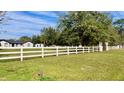 White fence and green lawn in front of home at 6747 Whispering Pines Rd, Orlando, FL 32824