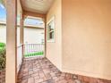 Side porch with brick flooring and white railing at 153 Marabella Loop, Poinciana, FL 34759