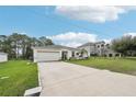 Front view of a house with a driveway and landscaping at 151 Flatfish Ct, Poinciana, FL 34759