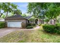 Brick home with a landscaped lawn, walkway, and attached garage at 840 Coach Lamp Ct, Sanford, FL 32771