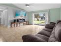 Bright living room with tiled floors, large TV, and sliding doors leading to the backyard at 617 Brockton Dr, Kissimmee, FL 34758