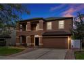 Two story home with tan exterior, two car garage, and landscaped yard at 10233 Serotina Ct, Orlando, FL 32832