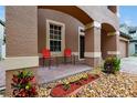 Front porch with red chairs and landscaping at 10233 Serotina Ct, Orlando, FL 32832