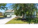 Light green house exterior with 2-car garage and landscaping at 3260 Marshfield Preserve Way, Kissimmee, FL 34746