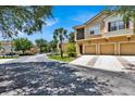 Exterior view of a two-story townhome with a two-car garage and landscaped grounds at 2732 Oakwater Dr # 101, Kissimmee, FL 34747