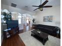 Living room with hardwood floors, leather sofas, and a view into another living area at 7953 Sea Pearl Cir, Kissimmee, FL 34747