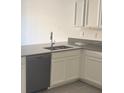 Modern kitchen with gray countertops and white cabinets at 7645 Danube Rd, Kissimmee, FL 34747